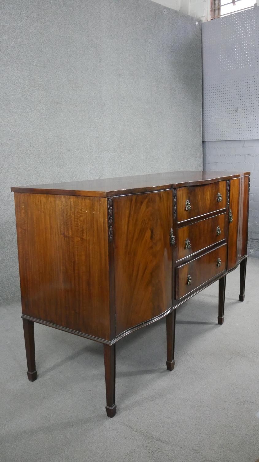 A Georgian style flame mahogany sideboard with husk carved decoration on square tapering supports. - Image 2 of 8