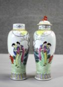 A pair of Famille Rose Chinese hand painted porcelain jars with lids (one missing), decorated with