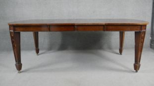 A C.1900 mahogany extending dining table with two extra leaves on husk carved square tapering