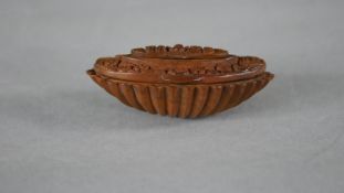 A 19th century coquilla nut shell snuff box with hinged cover decorated with flowers and smaller