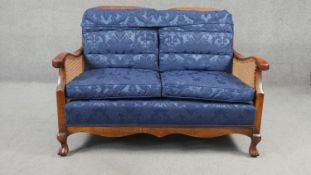 A mid century beech bergere sofa with caned back and sides on carved cabriole supports. H.80 W.113