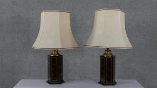A pair of lacquered tortoiseshell effect hexagonal table lamps with gilded linear detailing. Each
