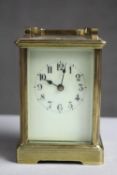 A C.1900's brass carriage clock with white enamel dial and chamfered glass panels. No key. H.6 W.4.