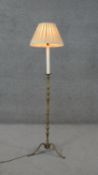 A vintage brass candle stick design tripod standard lamp with cream silk shade. H.138 W.40cm