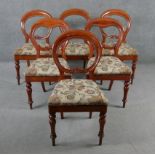 A matched set of six Victorian mahogany shaped and carved back dining chairs on turned tapering