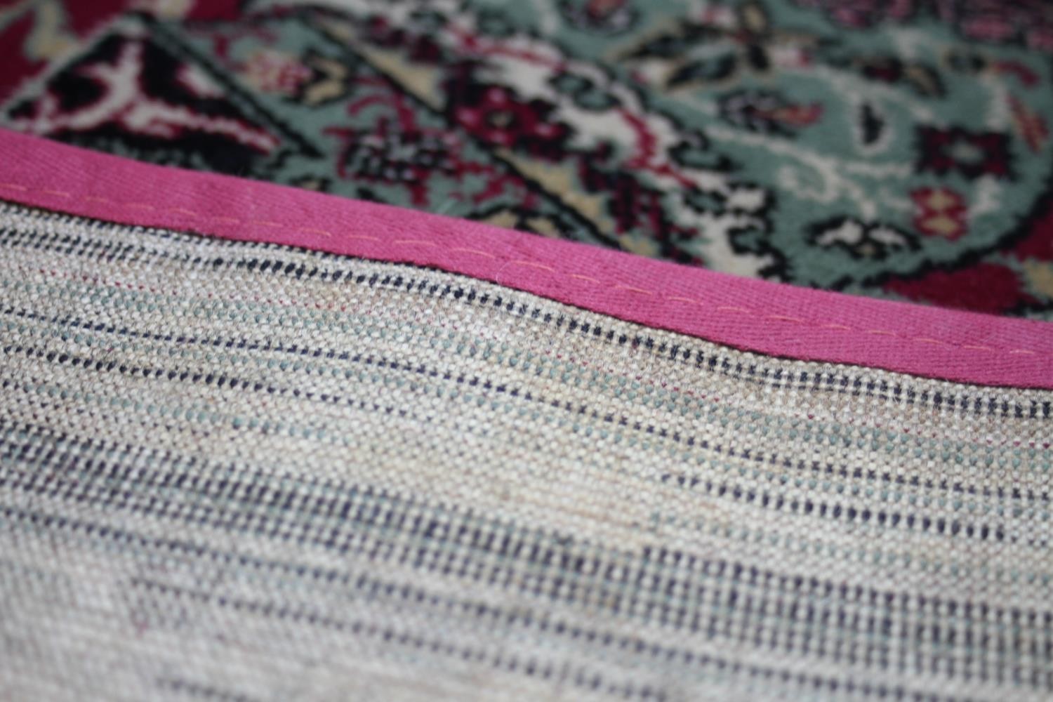 A large Wilton carpet with repeating floral medallions and trailing foliate decoration on a burgundy - Image 7 of 11