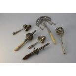 Six silver and white metal bells and children's rattles. Including two silver three bell and whistle