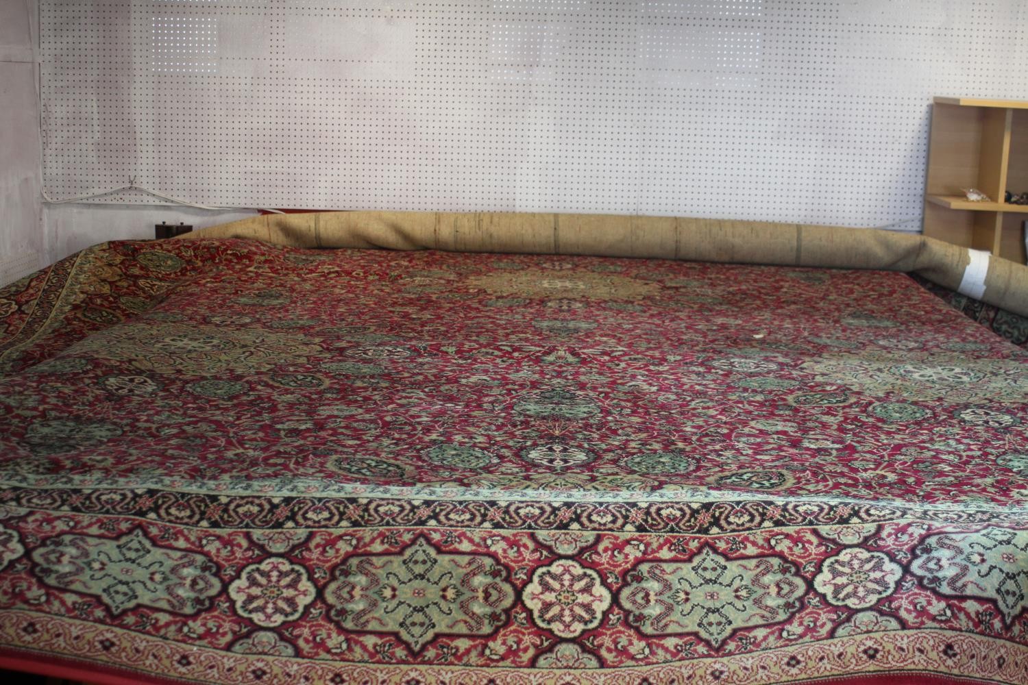 A large Wilton carpet with repeating floral medallions and trailing foliate decoration on a burgundy - Image 4 of 11