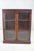 A mahogany bookcase with pair of glazed doors on plinth base. H.101 W.82 D.27 cm.