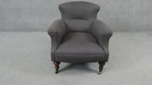 A 19th century tub armchair in piped calico upholstery on turned tapering mahogany supports.