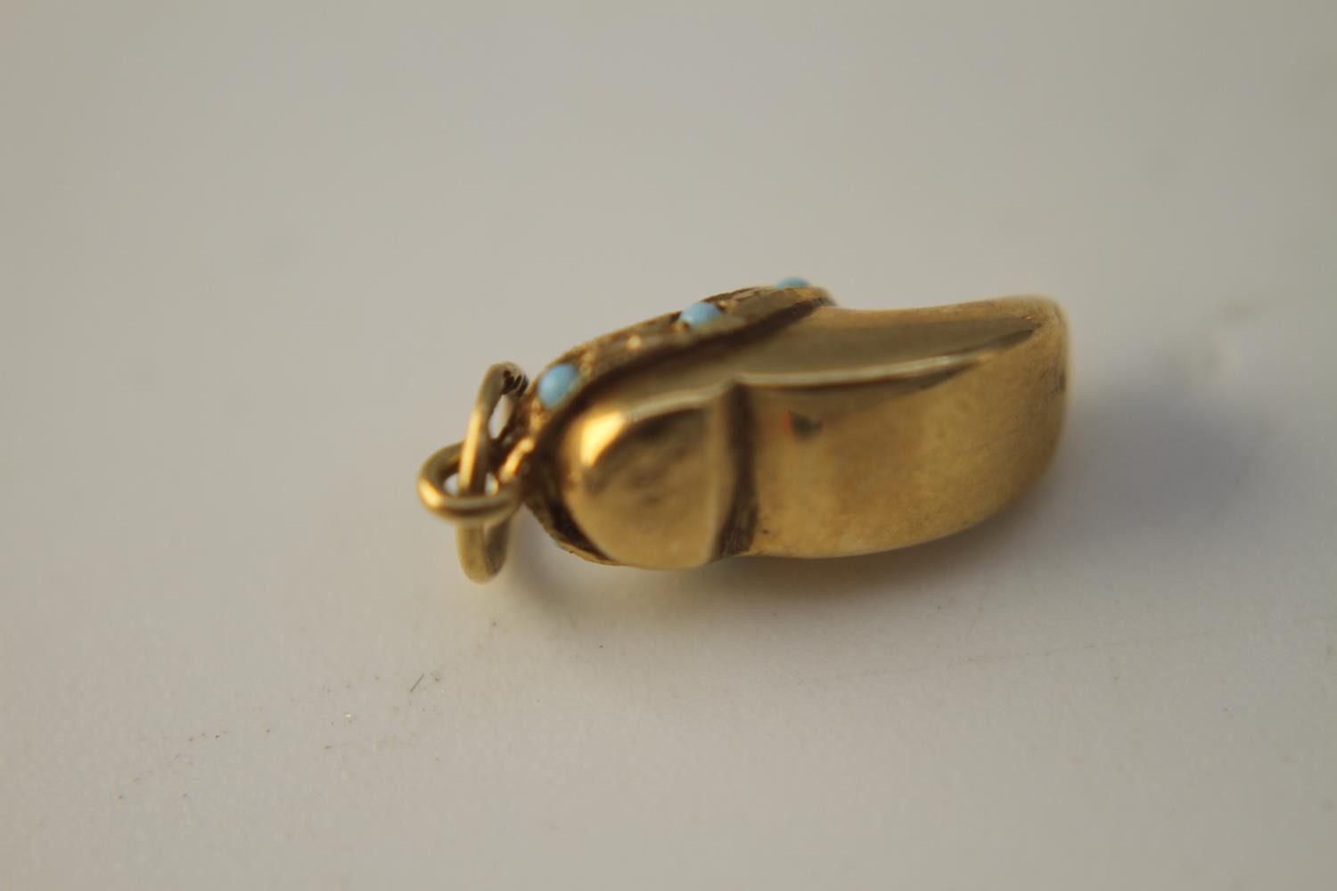 Four 14 carat yellow gold charms. Including a gold clog charm set with turquoise cabochons, a gold - Image 3 of 7
