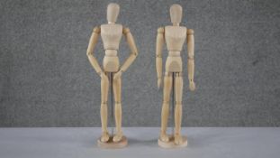 Two articulated wooden artists mannequins on circular stands. H.43 W.12cm