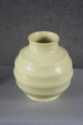 Keith Murray for Wedgwood, a pale yellow glazed ribbed globular vase. Makers stamp to the base. H.23