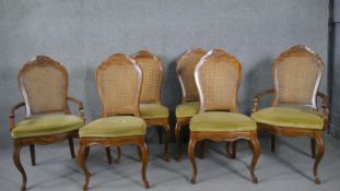A set of six French Provincial style carved walnut dining chairs with caned back and upholstered