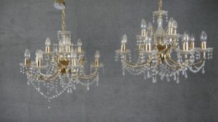 A pair of vintage brass and cut crystal twelve branch chandeliers with crystal swags and drops. H.60