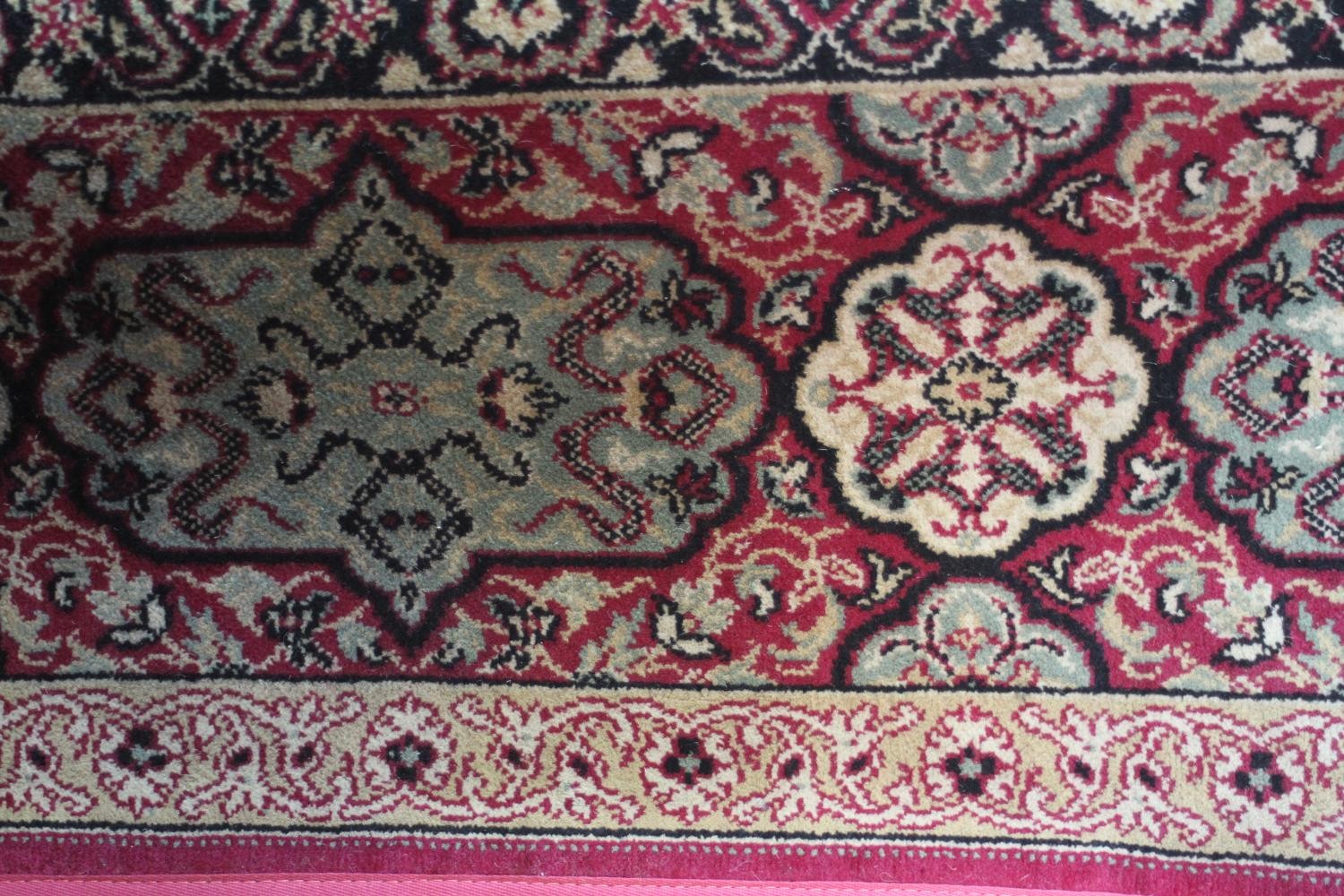 A large Wilton carpet with repeating floral medallions and trailing foliate decoration on a burgundy - Image 2 of 11