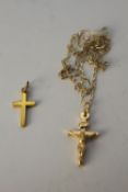 A yellow metal (tests higher than 9 carat) crucifix along with a 9 carat gold crucifix on a 9