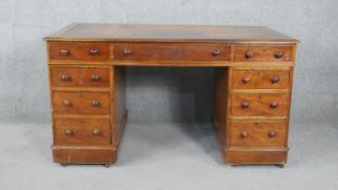 A Victorian mahogany three section pedestal desk with inset gilt tooled leather top on plinth