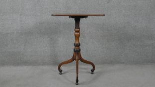 A 19th century mahogany tilt top table on turned column and tripod scrolling supports resting on