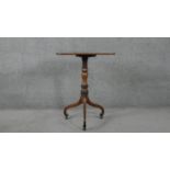 A 19th century mahogany tilt top table on turned column and tripod scrolling supports resting on