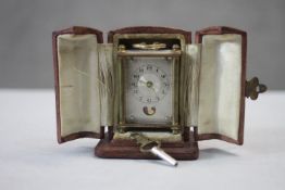 A leather fitted cased miniature 19th century Swiss gilt metal and mother of pearl carriage clock.