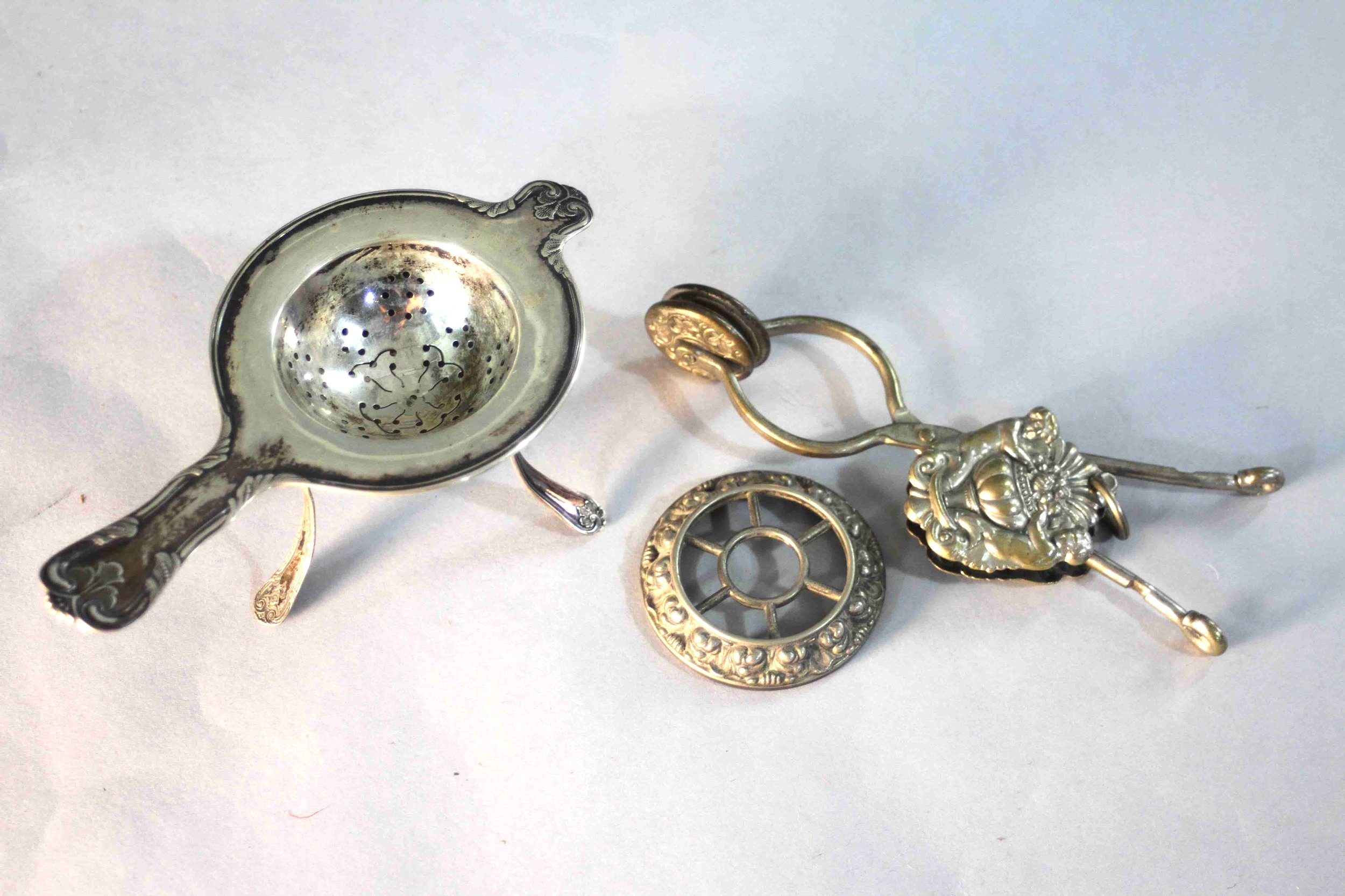 A Victorian silver plated skirt lifter with an urn and fruit design along with a Danish silver