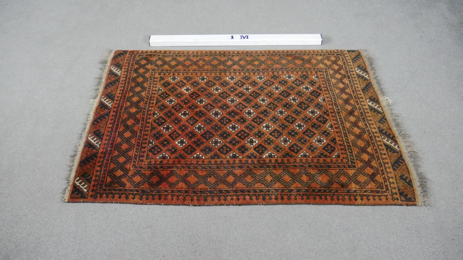 An Afghan rug with repeating stylised geometric motifs on a terracotta ground within multiple - Image 5 of 5