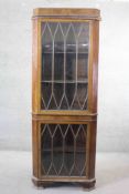 An early 20th century mahogany corner cabinet with astragal glazed doors standing on ogee bracket