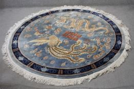 A Chinese carpet with chasing dragon and character motifs on a powder blue ground within a