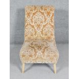 A vintage nursing chair in cut floral fabric on splay supports.