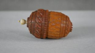 A 19th century carved coquilla nut sewing case in the form of an acorn with geometric design and