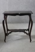 A C.1900 shaped top occasional table on cabriole supports united by under tier. H.67 W.64 D.41 cm.