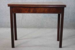 A Georgian mahogany foldover top tea table with gateleg action on reeded square chamfered