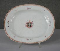 A 19th century hand painted porcelain armorial crest oval platter decorated with flowers and