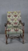 A 19th century Continental walnut armchair in stylised floral tapestry upholstery and lion carved