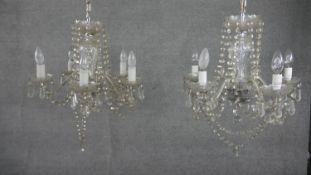 A pair of vintage cut crystal five branch chandeliers with hanging crystal drops and swags. H.33 W.