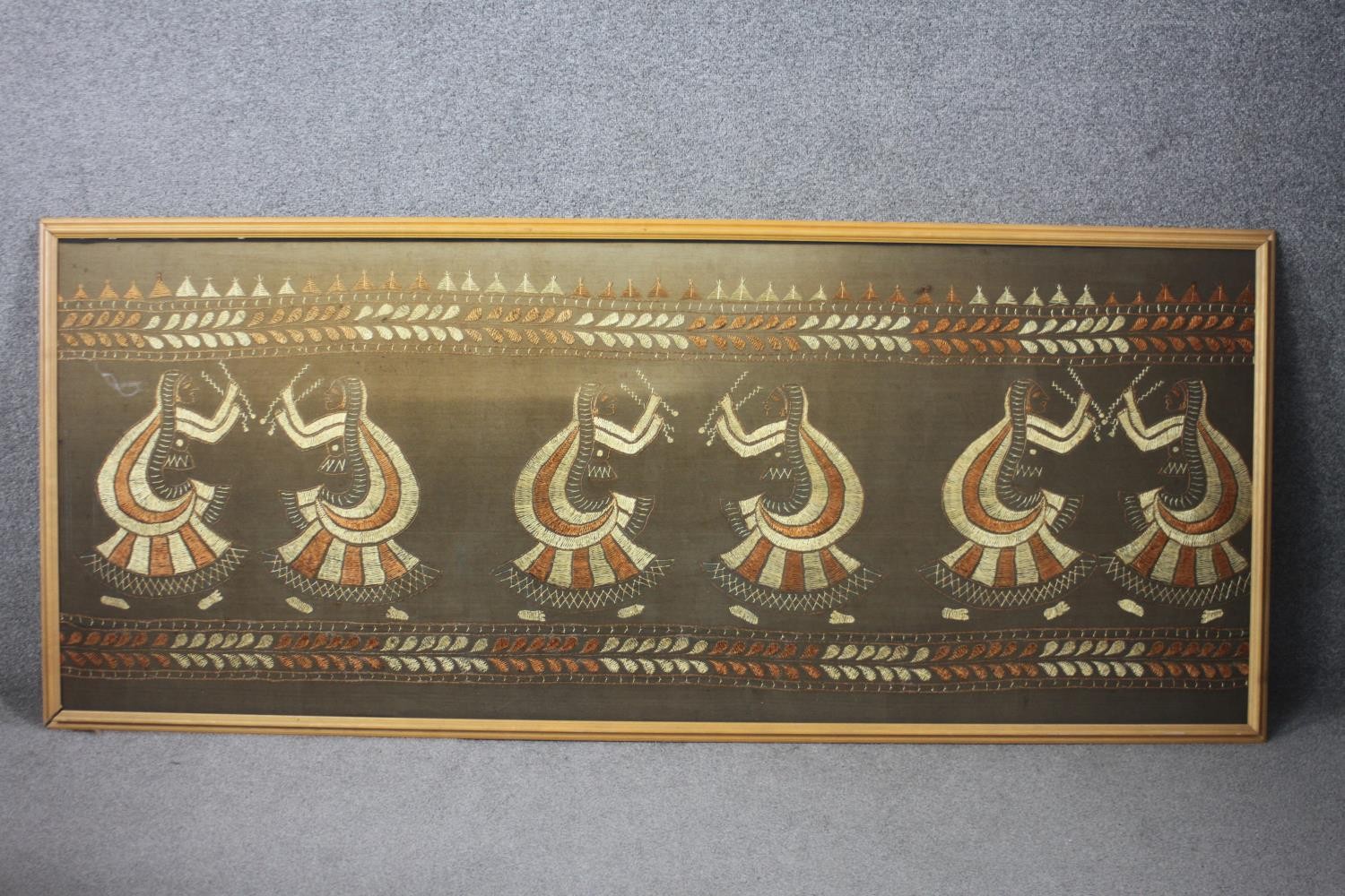 A large framed oriental silk needlework with dancing figures. H.80 W.193. cm