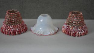 A pair of red and white beaded lampshades along with an opal and cranberry glass ruffled edge