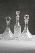 Three cut crystal decanters with stoppers. Two with cross hatched design and one with a stylised
