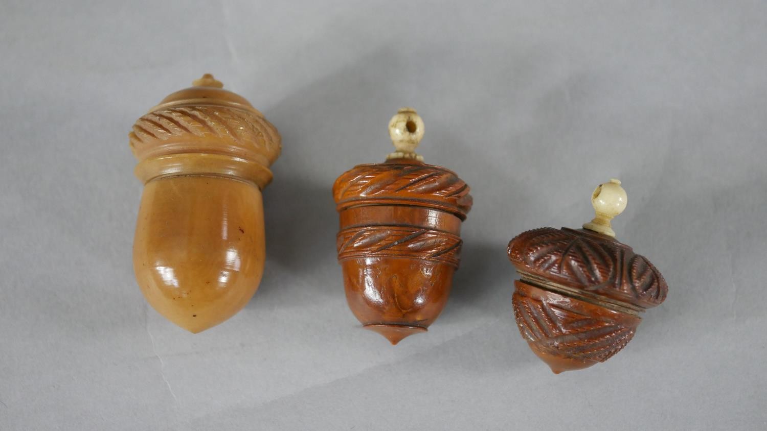 Three 19th century coquilla nut and vegetable ivory acorn design thimble holders. Each with a