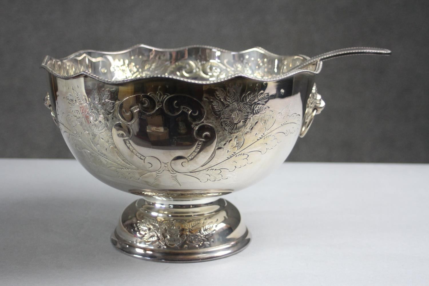 A hand chased floral design silver plate punch bowl and ladle. The pedestal bowl with twin lion head - Image 2 of 9