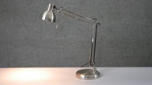 A brushed chrome anglepoise style adjustable desk lamp on circular base. H.34 W.36cm