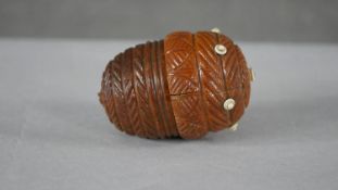 A 19th century carved coquilla nut sewing case in the form of an acorn with foliate design and