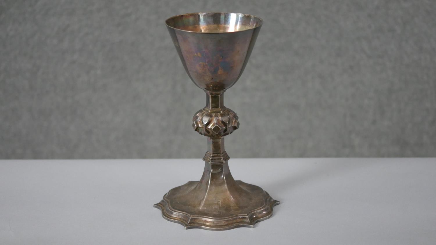 A Victorian silver communion cup. The lobed stem having raised bosses on a shaped plinth base.