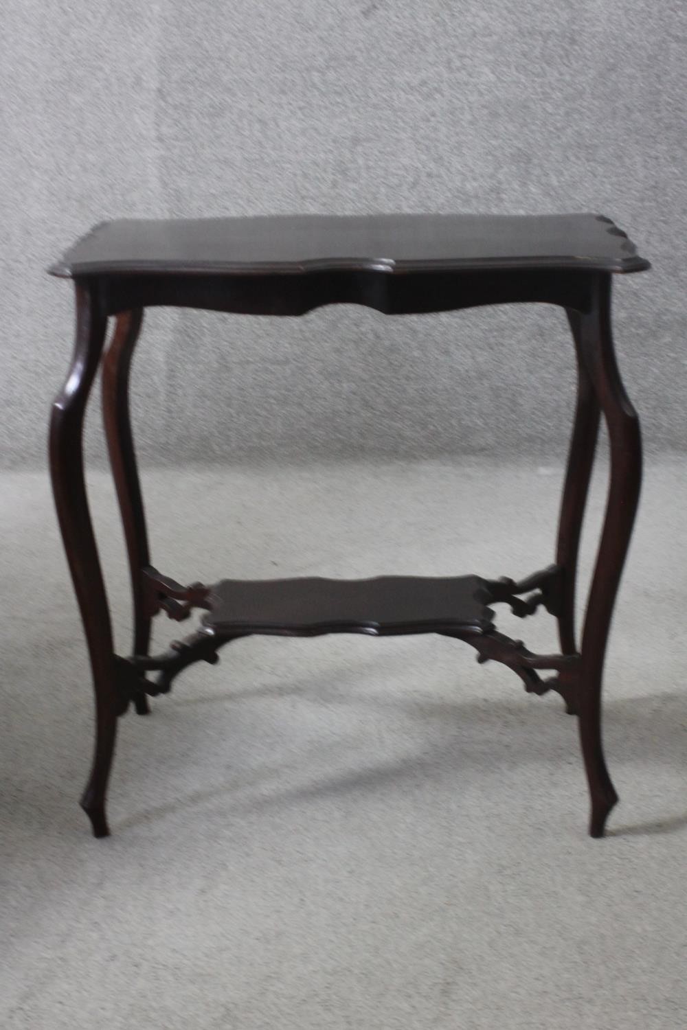A C.1900 shaped top occasional table on cabriole supports united by under tier. H.67 W.64 D.41 cm.