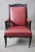 A late 19th century carved mahogany framed armchair in faux leather upholstery on turned supports.