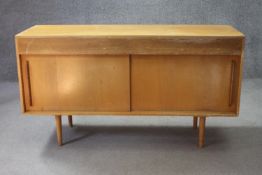 A mid century Robin Day Hilleplan teak sideboard with sliding doors on circular section shaped