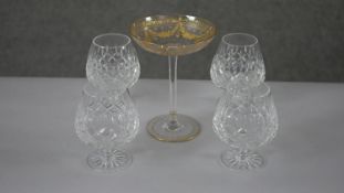 A set of four cut crystal brandy glasses along with a 19th century etched and gilded champagne
