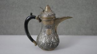 An Omani repousse silver foliate design Dallah coffee pot. Engraved with the national emblem of