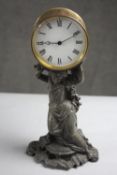 A spelter Victorian clock as a woman supporting the time piece. Brass mechanism and white enamel